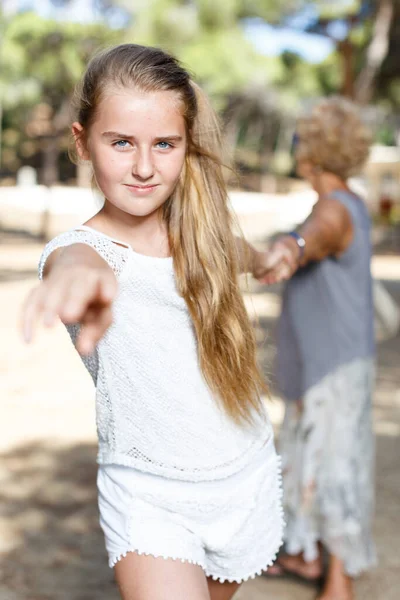 Teenage girl pulling hand and hold grandmother on hand in green park — Stock Photo, Image