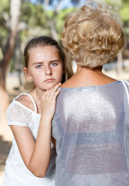 Infelice adolescente in verde parco abbraccio nonna a giornata di sole — Foto Stock