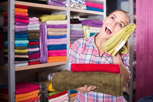 Mladá žena zákazník výběru různých ručníků — Stock fotografie