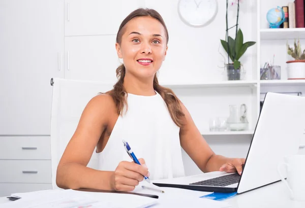 Портрет женщины-бизнес-сотрудницы, пишущей и работающей с ноутбуком в офисе — стоковое фото