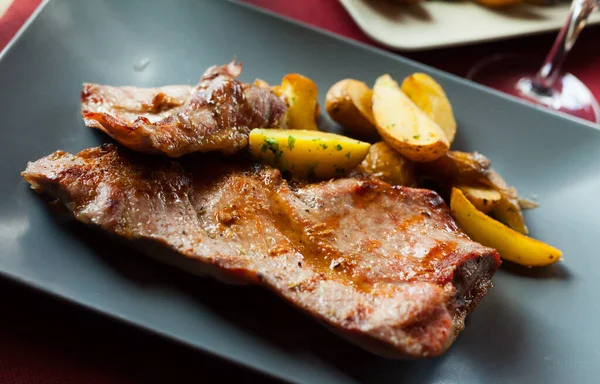 Picture of delicious fried iberian pork with fried potatoes at plate — Stock Photo, Image