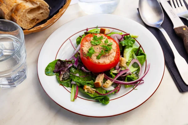 Läcker tomat fylld med tonfisk på en salladskudde — Stockfoto