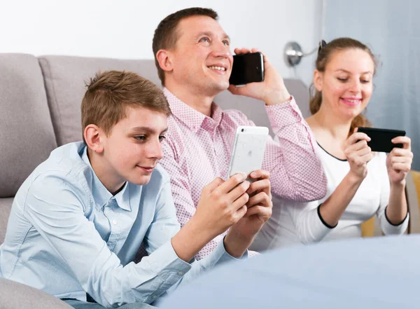 Parents and son using phones — Stock Photo, Image