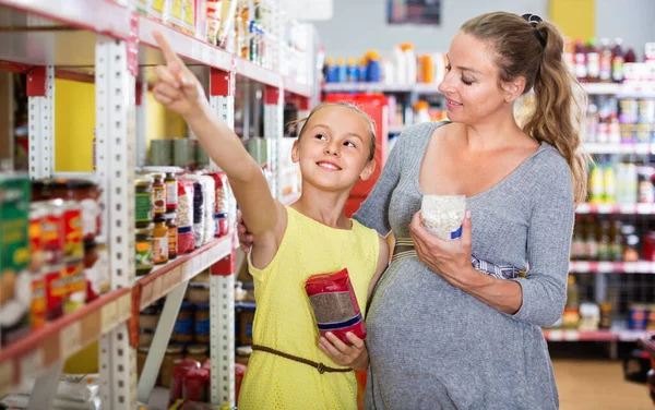 Žena s dcerou si vybírá čerstvé zboží v oddělení potravin — Stock fotografie