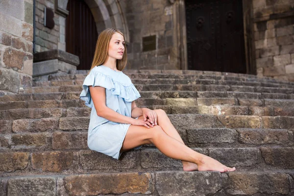 Девушка с светлыми волосами сидит на лестнице — стоковое фото