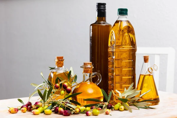 Olive oil in bottles on wooden table — Stock Photo, Image