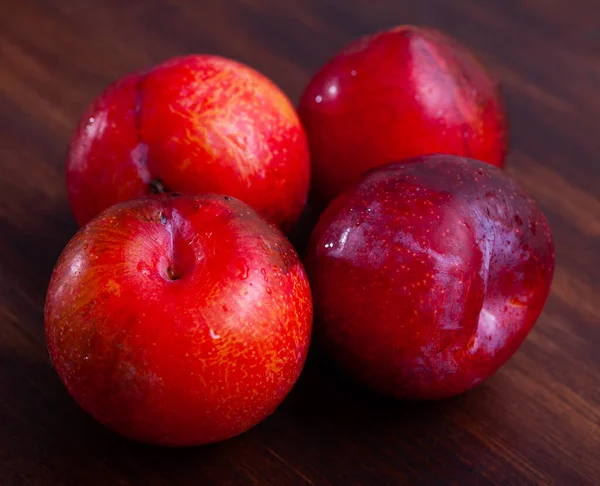 Plum merah manis di atas meja kayu — Stok Foto