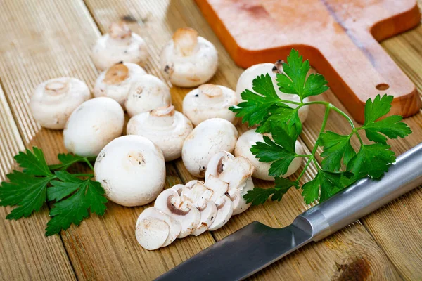 Closeup de cogumelo de champignon fresco cru inteiro em uma mesa de madeira branca. Cogumelos como proteína vegetal, dieta de alimentos crus, vegetarianismo — Fotografia de Stock