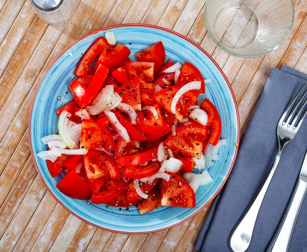 Čerstvý salát s rajčaty a nakrájenou cibulí — Stock fotografie