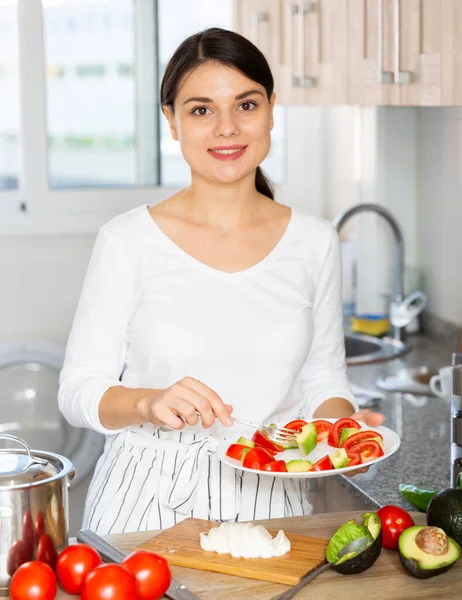 Woman tasting vegetable salad in kitchen — Stock Photo, Image