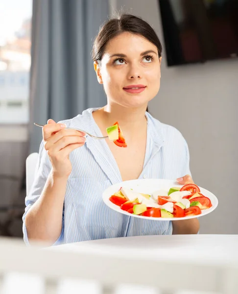 Mulher comendo salada à mesa — Fotografia de Stock