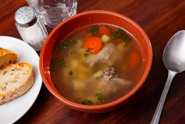 Homemade soup with pork meat on bone and vegetables — Stock Photo, Image