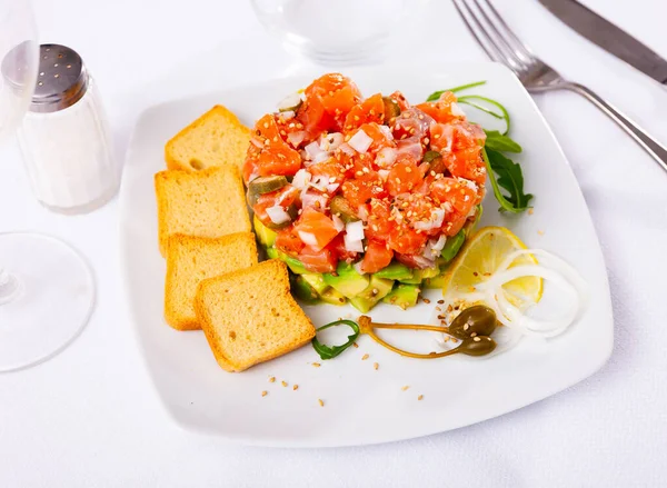 Salmon tartare with avocado served on plate — Stock Photo, Image