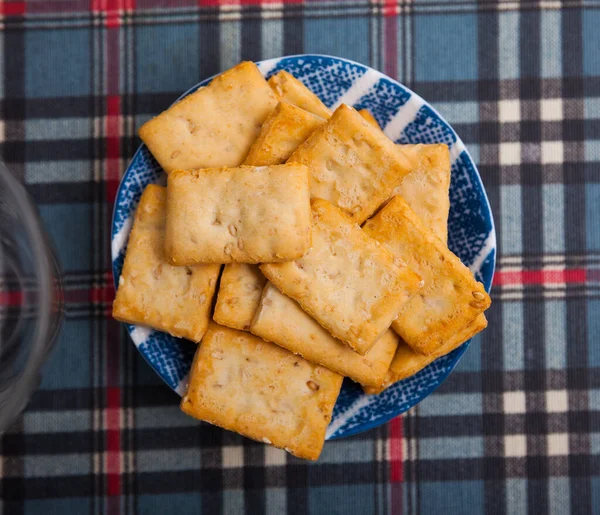 Dunne crackers met sesamzaad op bord — Stockfoto