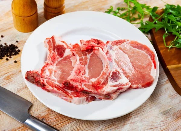 Chuletas frescas de lomo de cerdo crudo con condimentos —  Fotos de Stock