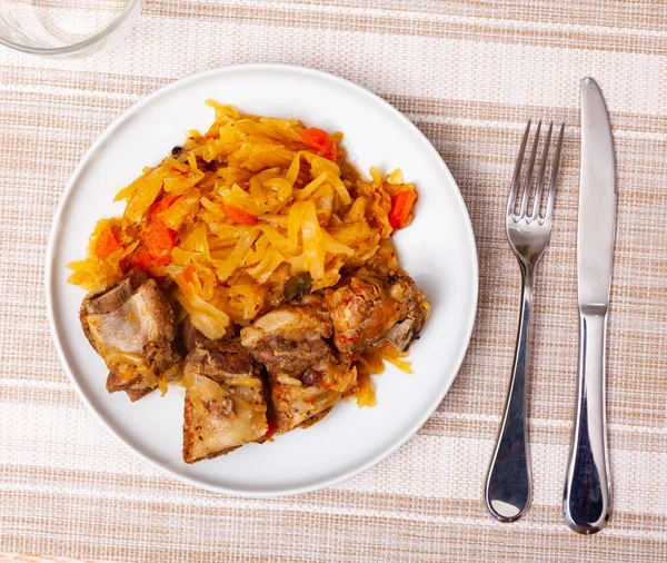 Teller mit geschmortem Sauerkraut mit gebratenem Schweinefleisch — Stockfoto