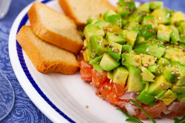 Closeup of salmon tartare with avocado served with toasts — Stock Photo, Image