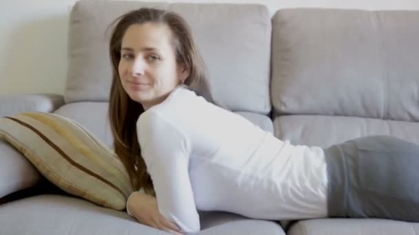 Retrato de mujer joven tumbada y relajada en el sofá en casa — Vídeo de stock