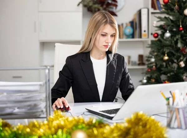 Επιτυχημένη επιχειρηματίας που χρησιμοποιεί φορητό υπολογιστή στο χώρο εργασίας κατά τη διάρκεια των Χριστουγέννων — Φωτογραφία Αρχείου