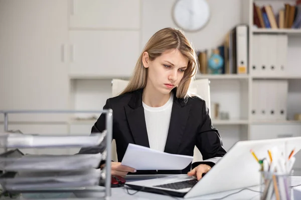 Trøtt forretningskvinne som arbeider med dokumenter i embetet – stockfoto