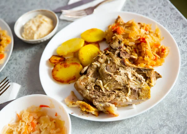 Pork meat with roasted potatoes and stewed cabbage — Stock Photo, Image