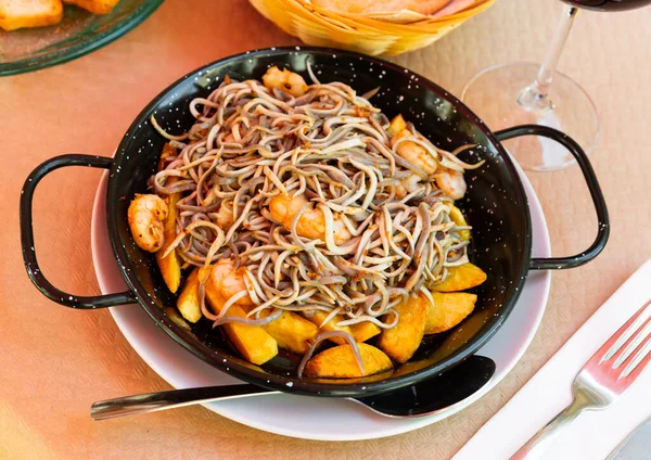 Тарелка вкусных жареных угрей и креветок с картошкой — стоковое фото