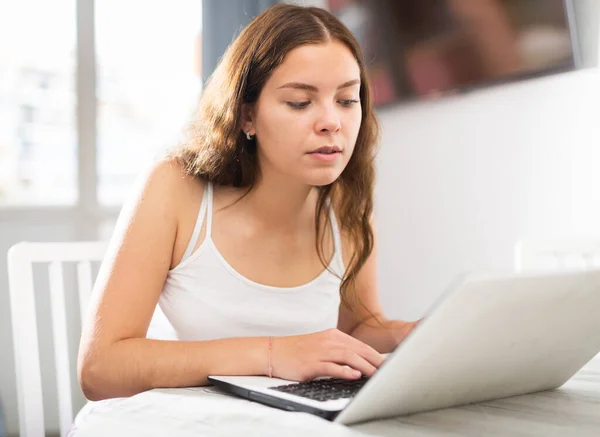Ung kvinna som arbetar på laptop hemma — Stockfoto