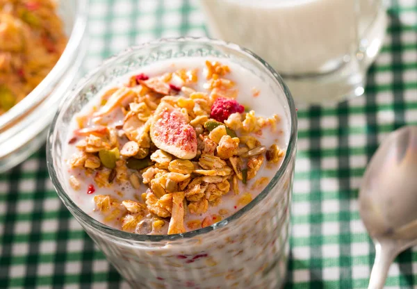 Oatmeal with dried fruit and milk in a glass. — ストック写真