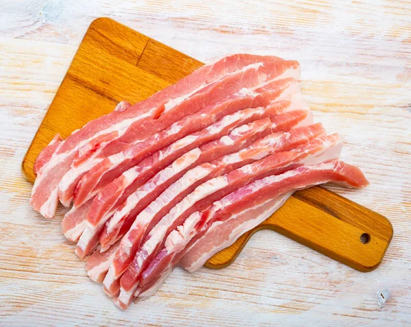 Närbild av rå bacon biffar på träytan — Stockfoto