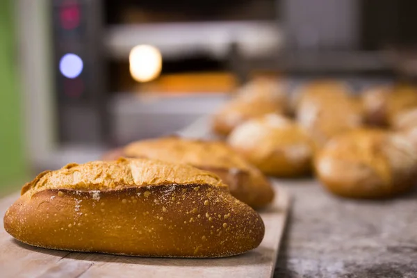 Горячий аппетитный хлеб на подносе пекарни — стоковое фото