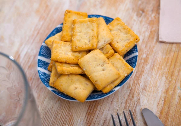 Crackers in a plate on a wooden table — Stock Photo, Image