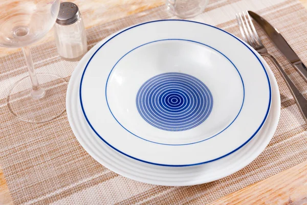 Empty ceramic plate with silverware on table — Stock Photo, Image