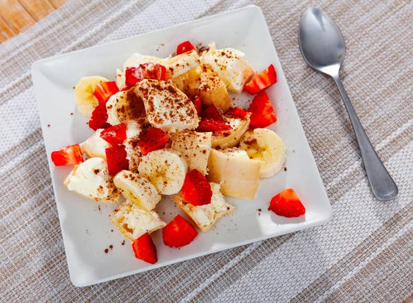 Ice cream with chopped strawberries and bananas served on table — стоковое фото