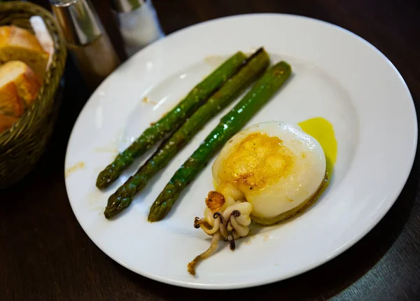 Calamares deliciosamente horneados con espárragos en un plato blanco — Foto de Stock