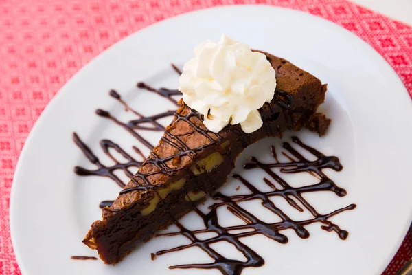 Bolo de brownie saboroso servido com creme de manteiga e chocolate escuro no prato — Fotografia de Stock