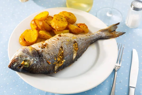 Baked in oven dorado fish with lemon and potatoes served — Stock Photo, Image