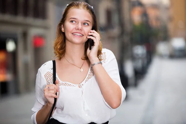 Портрет улыбающейся девочки-подростка, разговаривающей по телефону — стоковое фото