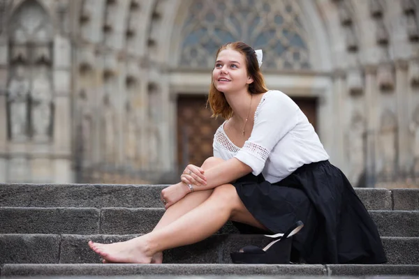Jovem fêmea positiva sentada nas escadas de pedra — Fotografia de Stock