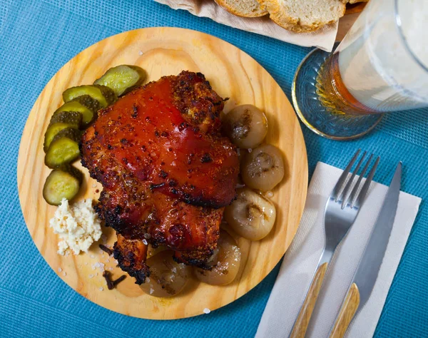 Oven baked pork knuckle with boiled onions and pickled cucumbers — Stock Photo, Image