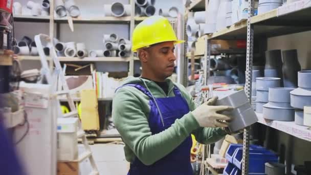 Cheerful Latino workman preparing for pipework routing, choosing supplies in shop of building materials — Stock Video