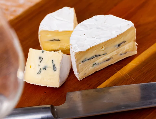 Whole wheel of piquant creamy blue cheese on cutting board — ストック写真