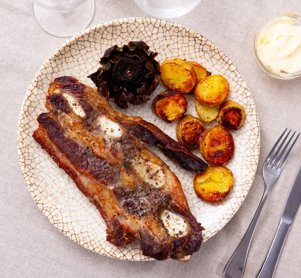 Grilled veal ribs churrasco with fried potatoes and artichokes —  Fotos de Stock