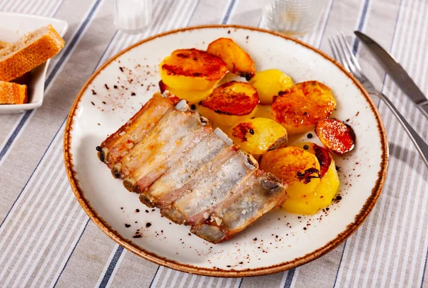 Appetizing baked pork ribs with fried sliced potatoes — Stock Photo, Image