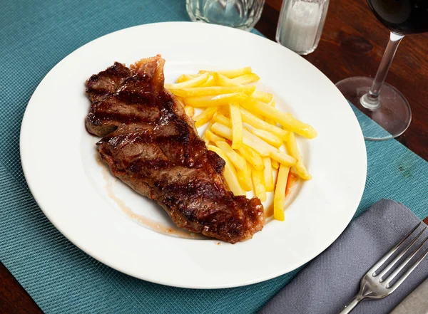 Steak de boeuf aux pommes de terre sur assiette blanche — Photo