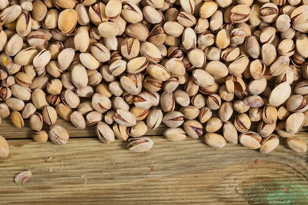 Pistachios on wooden surface — Stock Photo, Image