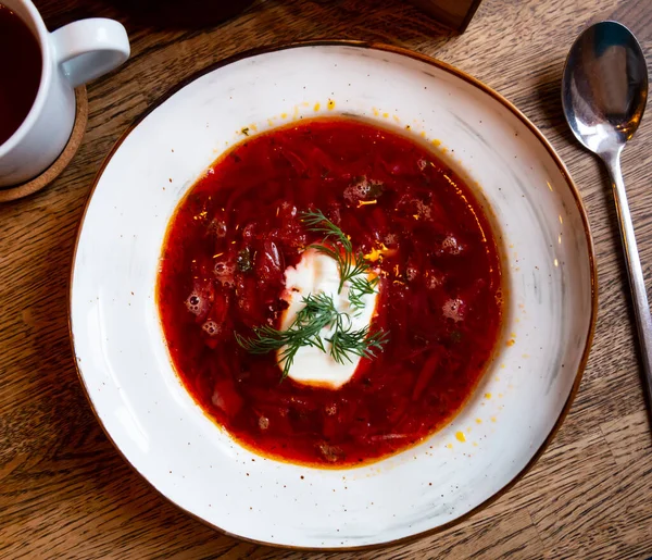 Plate of red borscht garnished with dill and smetana — Foto Stock