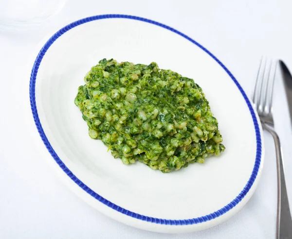 Pearl barley with spinach served in white circular plate — Stock fotografie