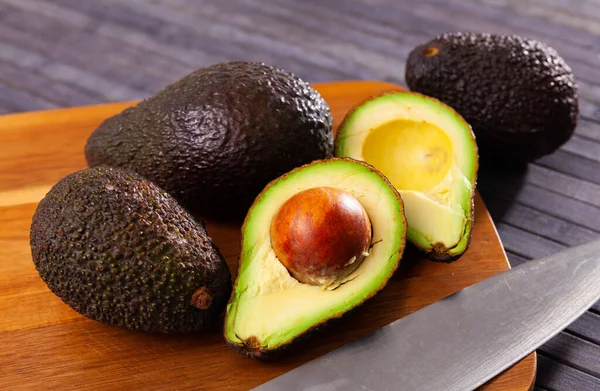 Raw organic avocado on wooden table — Stock fotografie