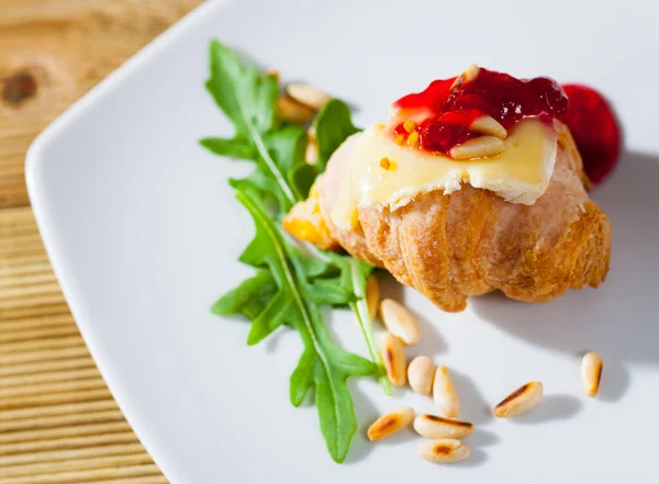 Croissant with camembert, jam and pine nuts — Stock fotografie