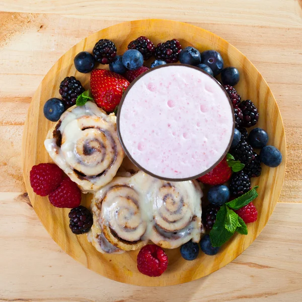 Top view of cinnamon rolls with milk smoothie and berries — Stock fotografie
